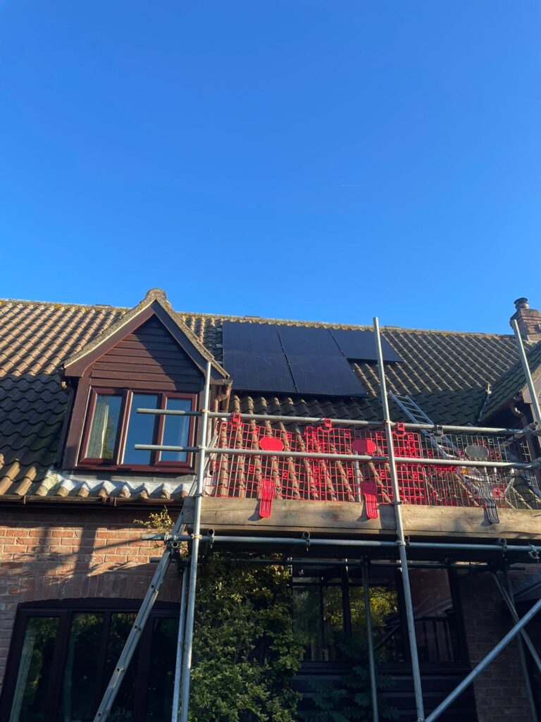 Ground view of solar panels being installed on a roof